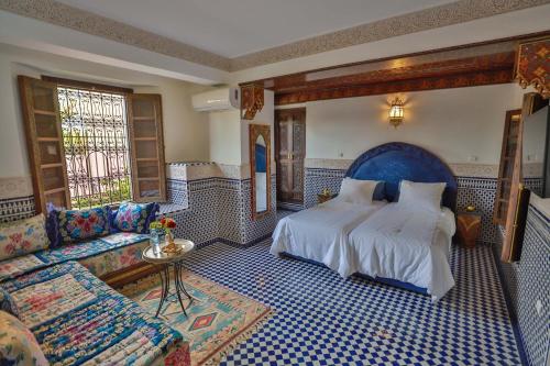 非斯Riad Semlalia的一间卧室配有一张大床和一张沙发