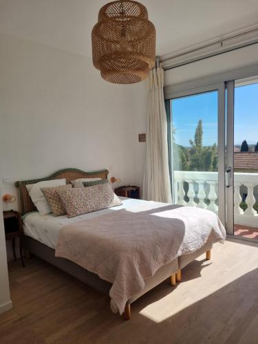 耶尔Villa Marguerite的一间卧室设有一张床和一个大窗户