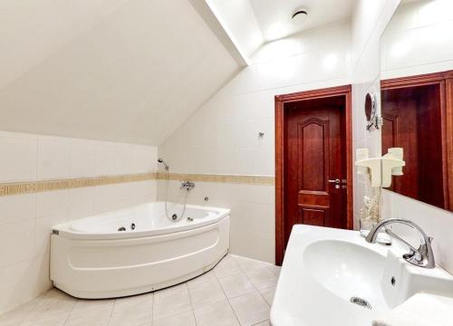 考纳斯Hotel Sfinksas的白色的浴室设有浴缸和水槽。