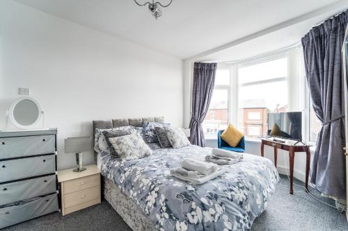 绍斯波特Birkdale Southport Boutique Apartment sleeps 5的一间卧室配有一张床、一张书桌和一个窗户。