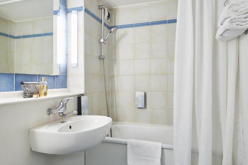 苏瓦松Kyriad Direct Soissons的白色的浴室设有水槽和淋浴。