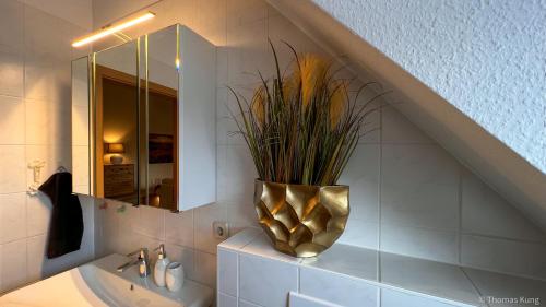 科特布斯Kungs Ferienwohnung的一间带水槽和花瓶的浴室