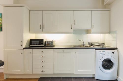 波特马多克Tegfryn (Sleeps 8), 5*, Sea View, Borth y Gest的厨房配有白色橱柜和洗衣机。