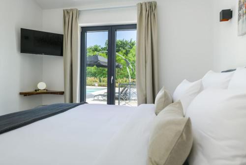 泽敏Villa Vetosa by IstriaLux的一间卧室设有一张床和一个滑动玻璃门