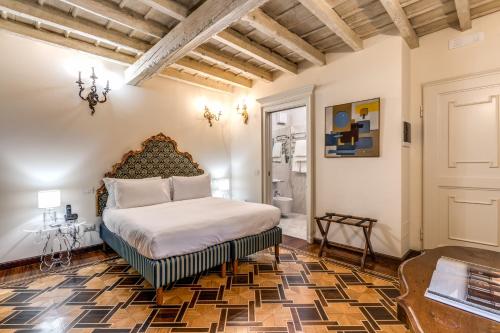 米兰圣玛尔塔套房酒店的一间卧室,卧室内配有一张大床
