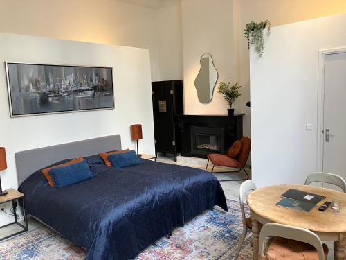 马斯特里赫特迪斯画廊酒店的一间卧室配有一张床、一张桌子和一个壁炉