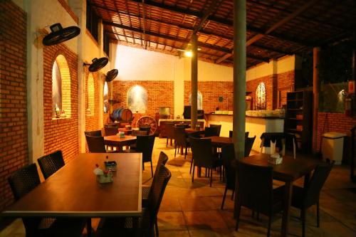 福塔莱萨Beleza Tropical Pousada Hotel的一间在房间内配有桌椅的餐厅