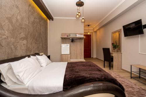 兹拉马Hotel Epavlis的酒店客房设有一张大床和一张书桌。