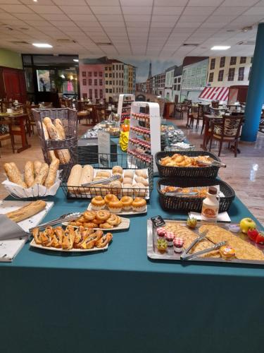 岩尼维利马尔索酒店的一张桌子,上面摆放着各种面包和糕点