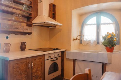 ViarádhikaKythera secrets suites的厨房配有水槽、炉灶和窗户。
