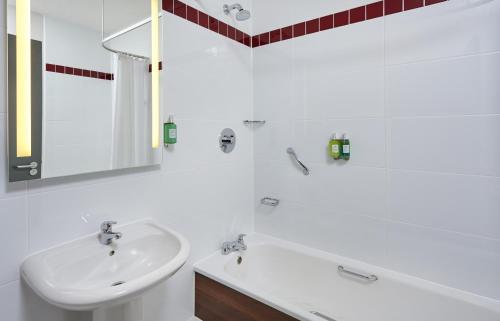 米尔顿凯恩斯Leonardo Hotel Milton Keynes的白色的浴室设有水槽和浴缸。