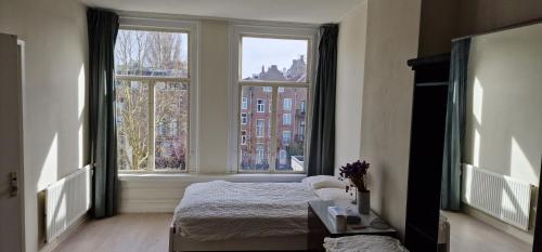阿姆斯特丹Frank’s and Chong’s excellent location的一间卧室设有一张床和两个大窗户