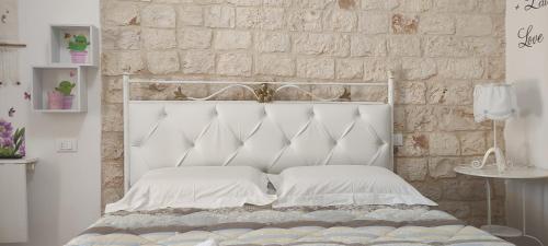 莫诺波利B&B Oceano的白色的床、白色枕头和砖墙