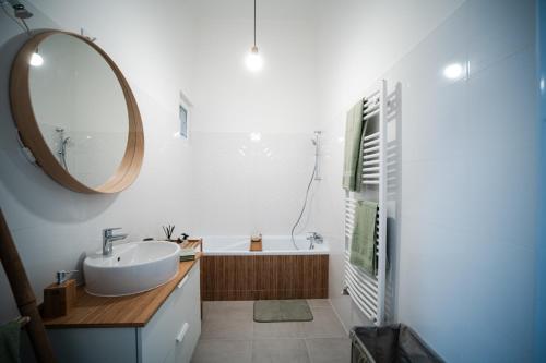 包姚Volenter Lux Apartment Uno的浴室配有盥洗盆、镜子和浴缸