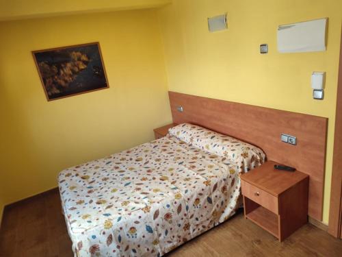 苏马拉加Pension Urola的一间带床和木桌的小卧室