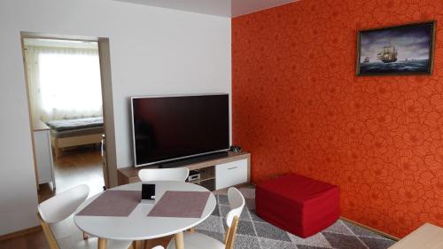 塔林Cozy Telliskivi apartment near city centre的客厅设有桌子和红色的墙壁