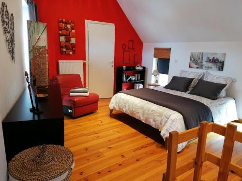 那慕尔Chambre d'hôte Les Volets Bleus的一间卧室设有一张床和红色的墙壁
