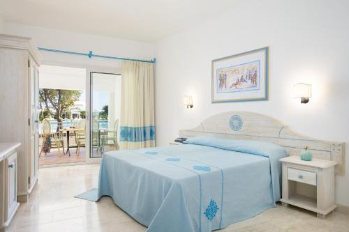 卡拉·利贝罗托Nicolaus Club Quattro Lune Resort的一间卧室配有一张床,享有庭院的景色
