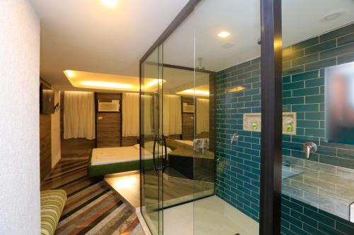 里约热内卢Eden Hotel (Adults Only)的浴室铺有蓝色瓷砖,设有玻璃淋浴间。