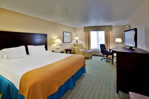 滑铁卢Holiday Inn Express- Waterloo/Cedar Falls, an IHG Hotel的酒店客房设有一张大床和一台电视。