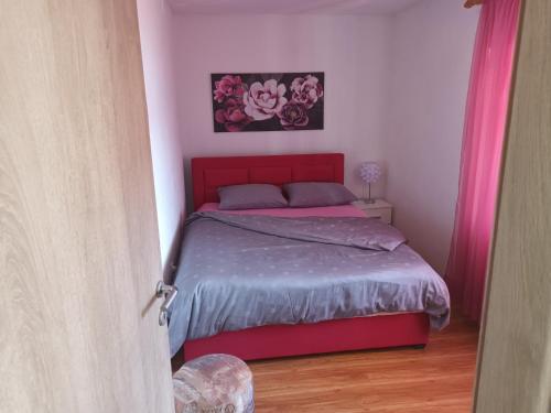 VrlikaHoliday home Marija的一间卧室配有一张红色床头板的床