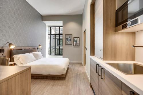 巴黎Mode Paris Aparthotel的酒店客房设有床和水槽