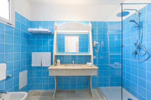 卡拉·利贝罗托Nicolaus Club Quattro Lune Resort的蓝色的浴室设有水槽和淋浴