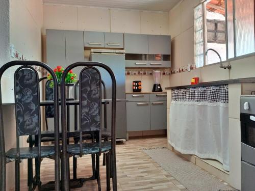 拉巴拉德纳圣米格尔Conforto 100 mts da praia的一间厨房,在房间内配有两把黑色椅子