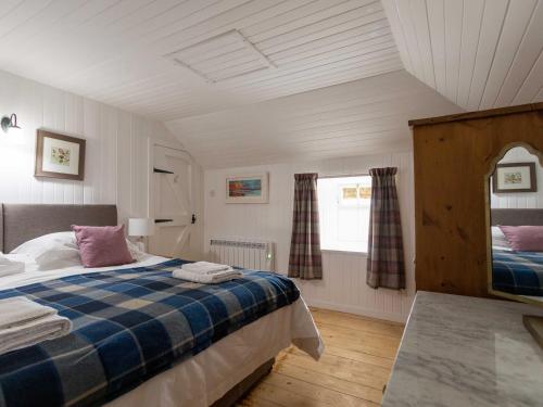 波特里Beaton's Croft House - Uig Skye的一间卧室设有一张床和一个窗口