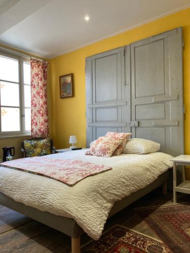 圣奥梅尔au 33 chambres d'hôtes的一间卧室设有一张黄色墙壁的大床