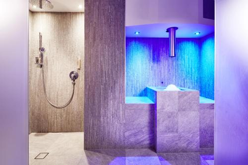 埃尔瓦尔德der grüne Baum Mountain Boutique Hotel的浴室配有紫色和蓝色的淋浴