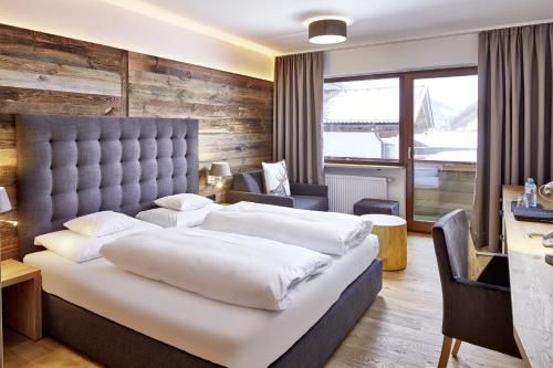 埃尔瓦尔德der grüne Baum Mountain Boutique Hotel的一间卧室配有一张大床和一张书桌