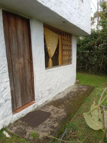 伊瓦拉ECOHUERTO的一间白色的小房子,有门和窗户