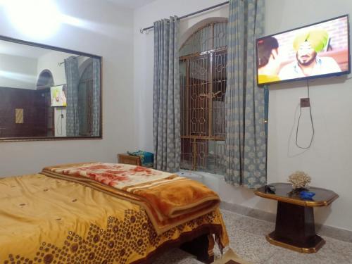 伊斯兰堡Room with Separate Entrance & Parking & Fast Wifi的卧室配有一张床,墙上配有电视。
