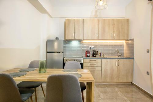 卡利斯托斯Vardians Villas & Suites的一间带桌椅的厨房和一间带冰箱的厨房