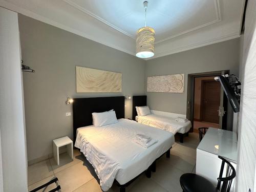 米兰博伽特酒店的带两张床和玻璃桌的房间