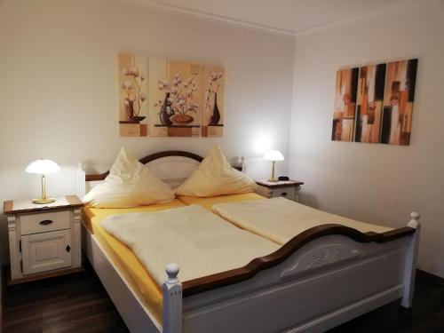 格雷文Ferienhof Große Drieling的一间卧室配有一张带两张桌子和两盏灯的床。