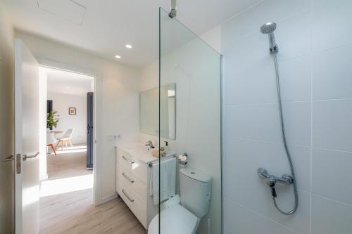 卡拉达沃White suites 3的一间带卫生间和玻璃淋浴间的浴室