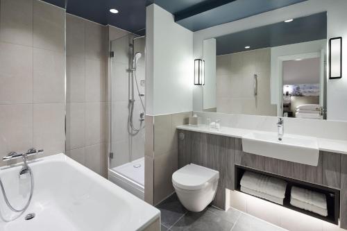 伯恩茅斯万豪伯恩茅斯高崖酒店的浴室配有盥洗盆、卫生间和浴缸。