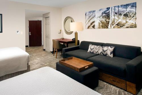 杰克逊维尔SpringHill Suites by Marriott Jacksonville North I-95 Area的酒店客房设有一张沙发和一张床