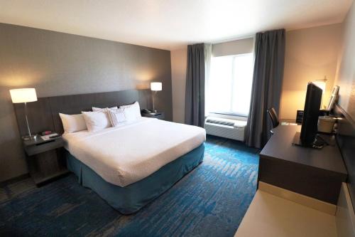 德梅因德梅因机场费尔菲尔德客栈的酒店客房,配有床和电视