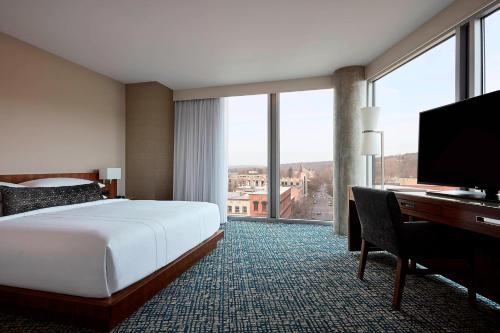 伊萨卡伊萨卡市中心下议院万豪酒店的酒店客房配有一张床、一张书桌和一台电视。