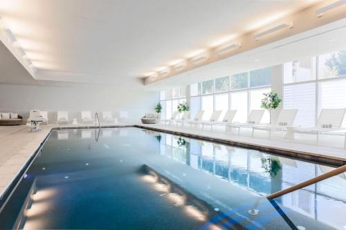 达拉斯达拉斯市中心万豪酒店的一座带白色椅子的大型游泳池