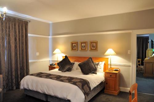 伍斯特Cumberland Hotel Worcester的酒店客房,配有一张床和两盏灯