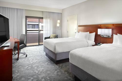格林维尔格林维尔海伍德购物中心万怡酒店的酒店客房设有两张床、一张桌子和一台电视。