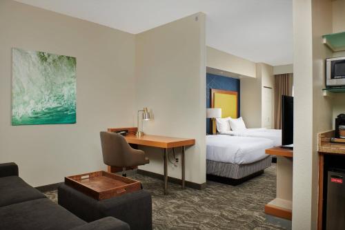 巴吞鲁日巴顿鲁日北/机场万豪春季山丘套房酒店的配有一张床和一张书桌的酒店客房