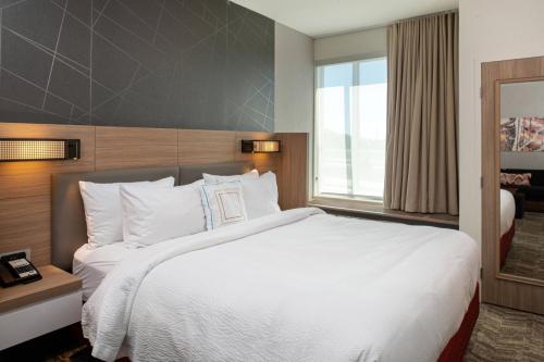 堪萨斯城SpringHill Suites by Marriott Kansas City Northeast的一间设有大床和窗户的酒店客房