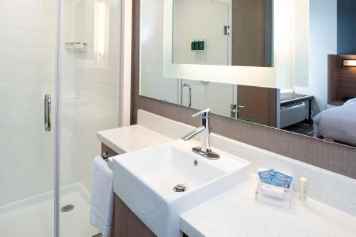 堪萨斯城SpringHill Suites by Marriott Kansas City Northeast的一间带水槽、淋浴和镜子的浴室