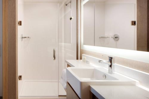 埃姆斯SpringHill Suites by Marriott Ames的白色的浴室设有2个盥洗盆和淋浴。