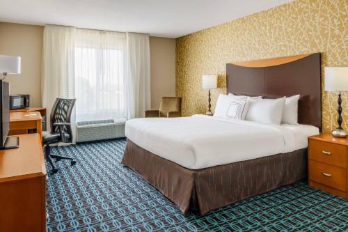 皮奥里亚Fairfield by Marriott Peoria East的酒店客房设有一张大床和一张书桌。